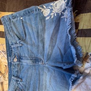 Jean shorts with white floral detailing.